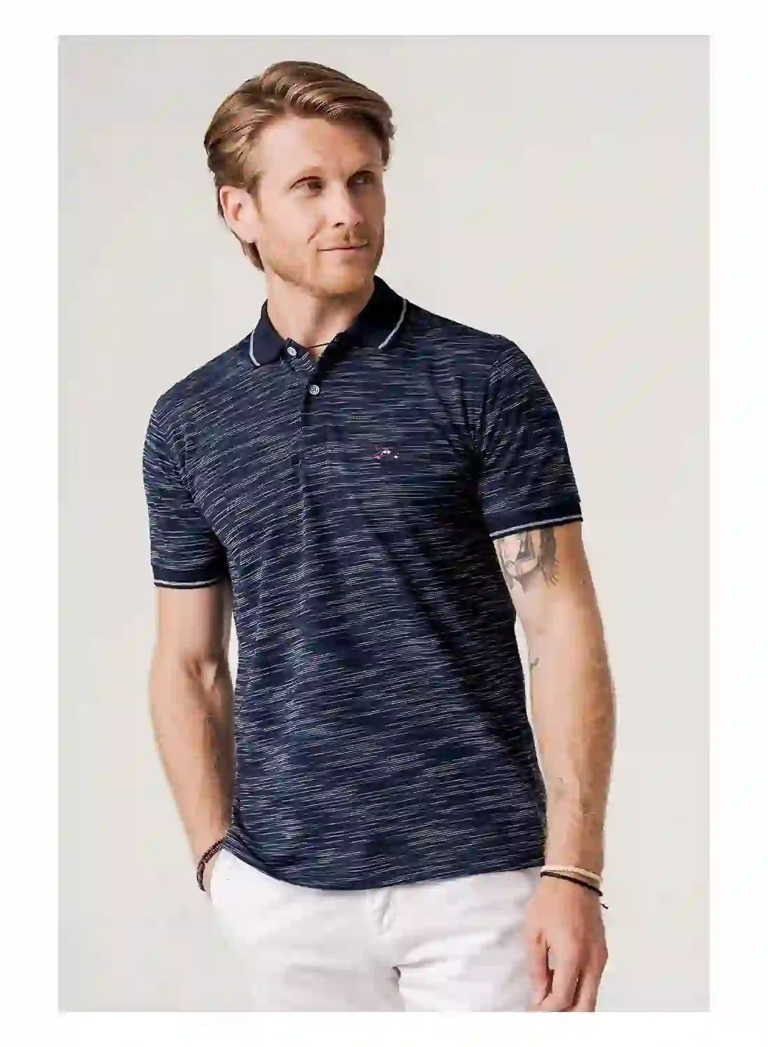 Hombre vistiendo camisa estampada de The Surfcar con diseño moderno y estilo desenfadado en entorno urbano veraniego